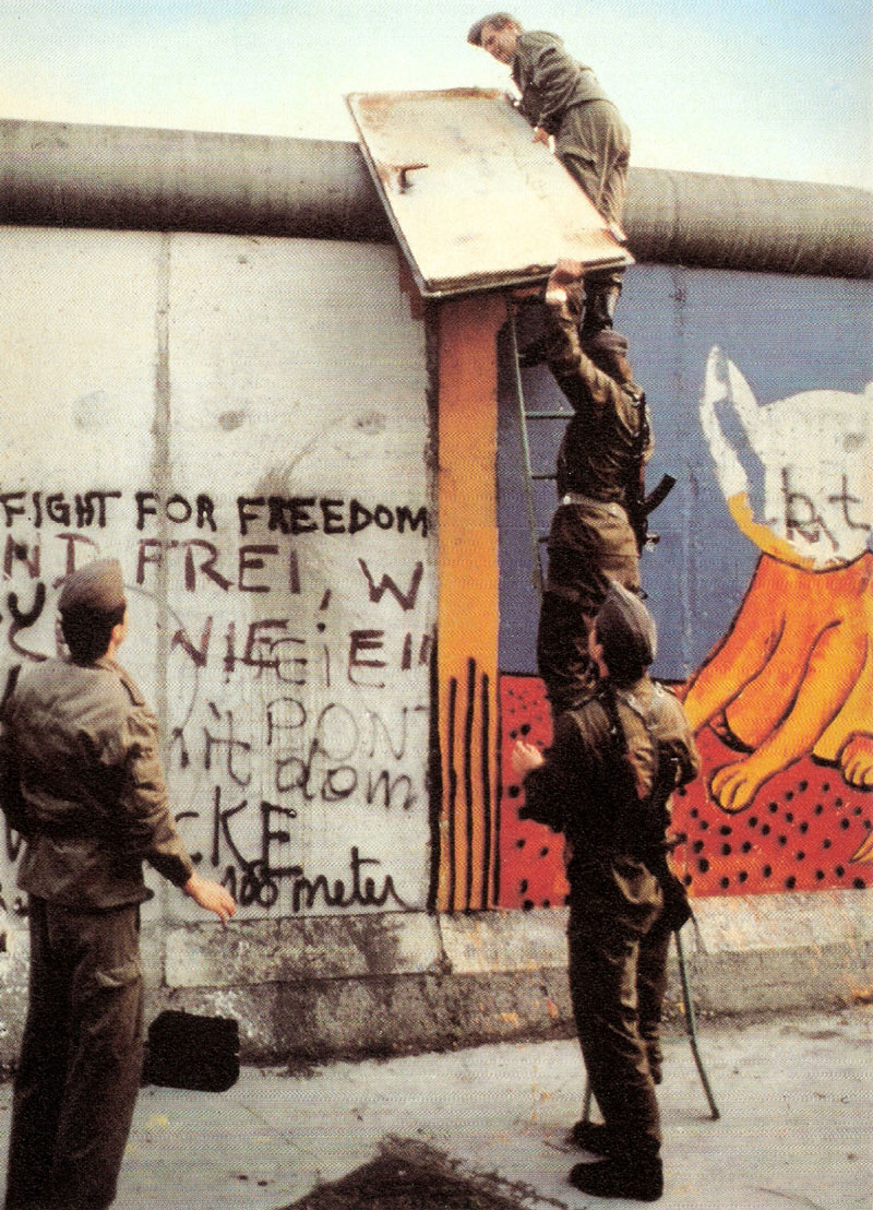 GDR soldiers removing a heavy iron door from the Berlin Wall and taking back to East Berlin after Noir had stuck it to the Wall.